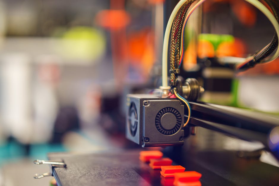 Detaljan snimak 3D pisača koji ekstrudira crvenu plastiku